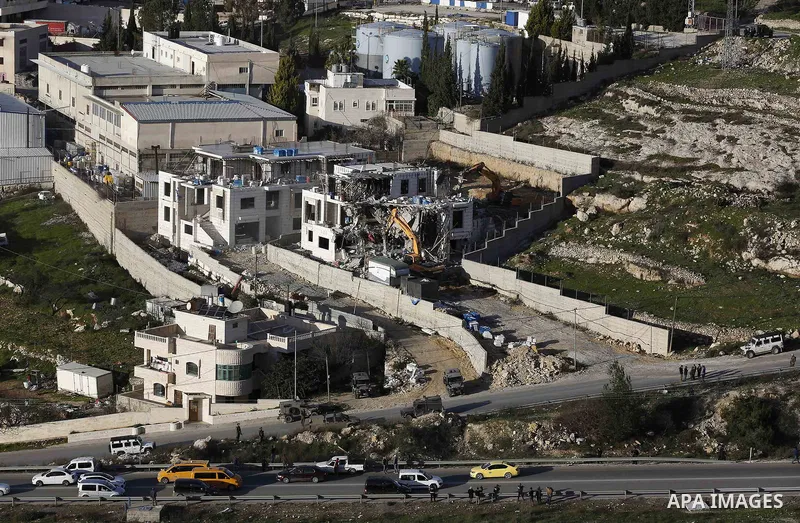 An Israeli machinery demolishes an under-construction Palestinian residential building near Hebron, in the occupied West Bank February 14, 2018. Photo by Wisam Hashlamoun