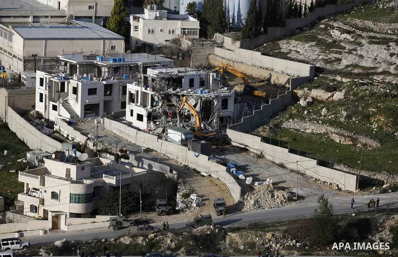 An Israeli machinery demolishes an under-construction Palestinian residential building near Hebron, in the occupied West Bank February 14, 2018. Photo by Wisam Hashlamoun
