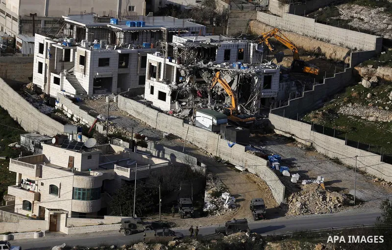 An Israeli machinery demolishes an under-construction Palestinian residential building near Hebron, in the occupied West Bank February 14, 2018. Photo by Wisam Hashlamoun