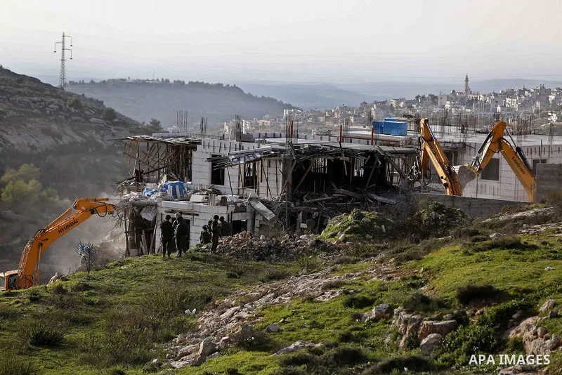 An Israeli machinery demolishes an under-construction Palestinian residential building near Hebron, in the occupied West Bank February 14, 2018. Photo by Wisam Hashlamoun