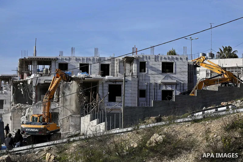An Israeli machinery demolishes an under-construction Palestinian residential building near Hebron, in the occupied West Bank February 14, 2018. Photo by Wisam Hashlamoun