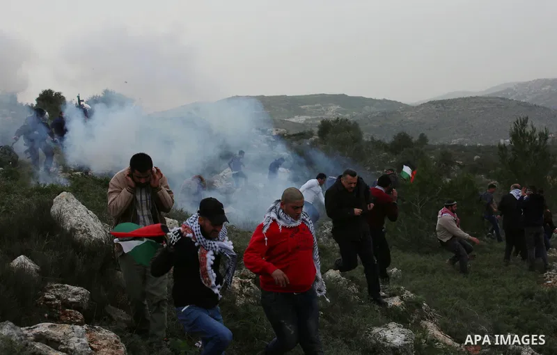 Palestinian protesters stand in a cloud of tear gas fired by Israeli troops during clashes at the Beta village near the West Bank city of Nablus, 15 February 2018. According to local sources at least five Palestinian wer...