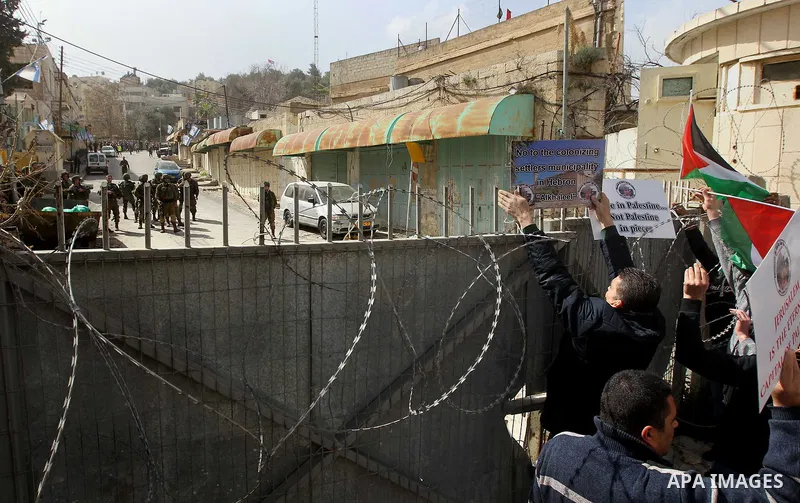 Palestinian protesters take part in a demonstration demanding to dismantle the Ghetto, to mark the 24th anniversary of Ibrahimi mosque massacre when Baruch Goldstein an Israeli settler opened fire and killing 29 Palestin...
