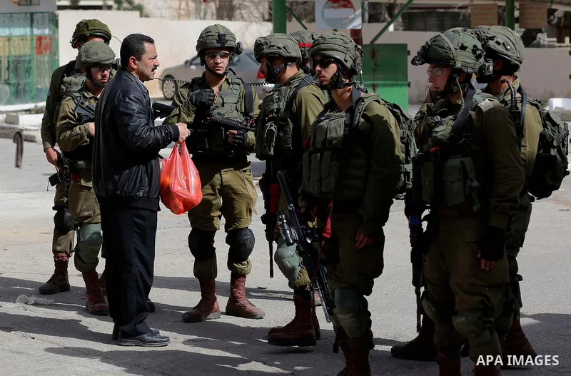 A Palestinian protester argues with Israeli soldiers during clashes following a demonstration demanding to dismantle the Ghetto, to mark the 24th anniversary of Ibrahimi mosque massacre when Baruch Goldstein an Israeli s...