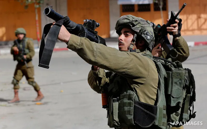 Israeli soldiers take position during clashes with Palestinian protesters following a demonstration demanding to dismantle the Ghetto, to mark the 24th anniversary of Ibrahimi mosque massacre when Baruch Goldstein an Isr...