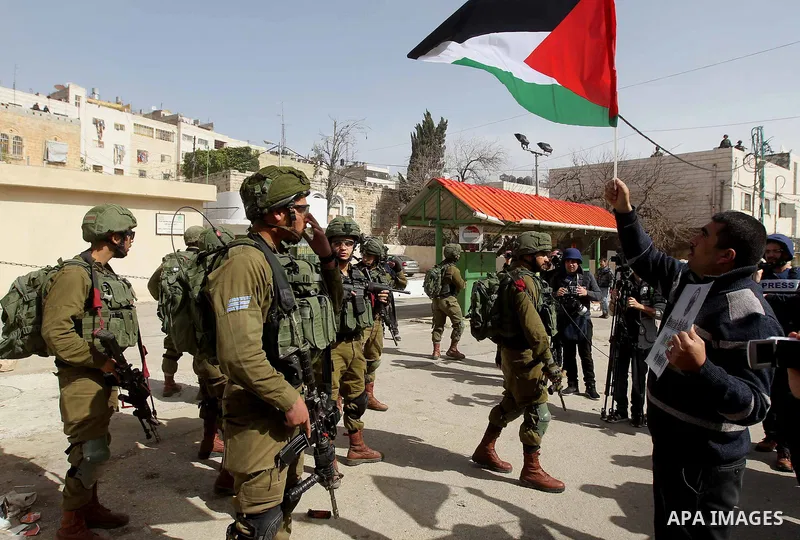 Israeli soldiers take position during clashes with Palestinian protesters following a demonstration demanding to dismantle the Ghetto, to mark the 24th anniversary of Ibrahimi mosque massacre when Baruch Goldstein an Isr...