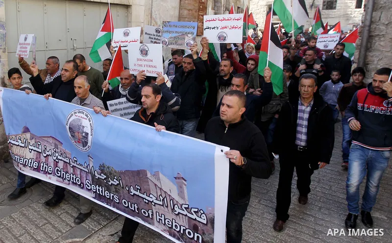 Palestinian protesters take part in a demonstration demanding to dismantle the Ghetto, to mark the 24th anniversary of Ibrahimi mosque massacre when Baruch Goldstein an Israeli settler opened fire and killing 29 Palestin...