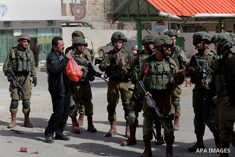 A Palestinian protester argues with Israeli soldiers during clashes following a demonstration demanding to dismantle the Ghetto, to mark the 24th anniversary of Ibrahimi mosque massacre when Baruch Goldstein an Israeli s...