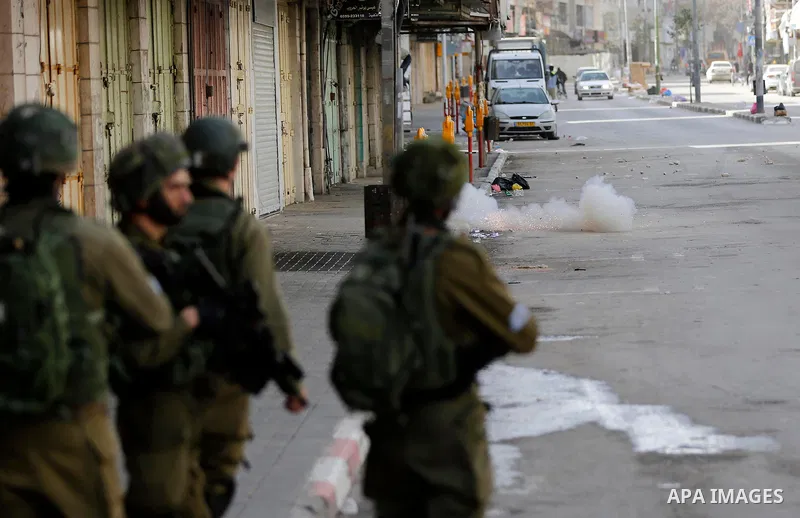 Israeli soldiers take position during clashes with Palestinian protesters following a demonstration demanding to dismantle the Ghetto, to mark the 24th anniversary of Ibrahimi mosque massacre when Baruch Goldstein an Isr...