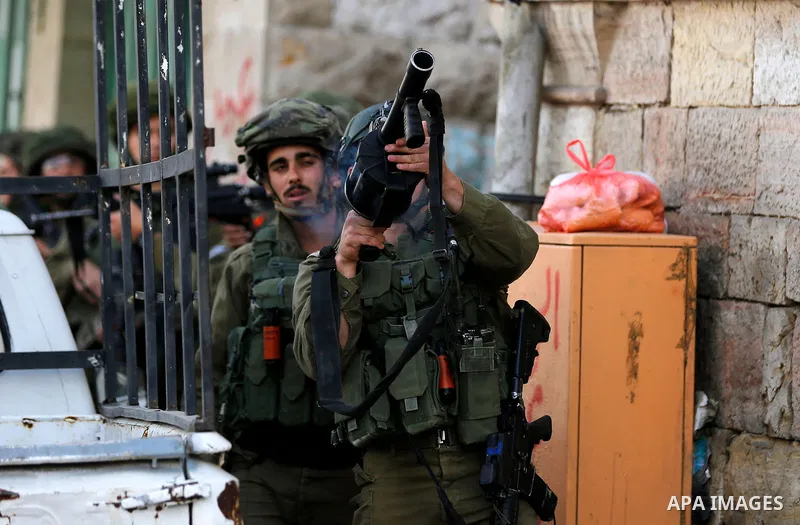 Israeli soldiers take position during clashes with Palestinian protesters following a demonstration demanding to dismantle the Ghetto, to mark the 24th anniversary of Ibrahimi mosque massacre when Baruch Goldstein an Isr...