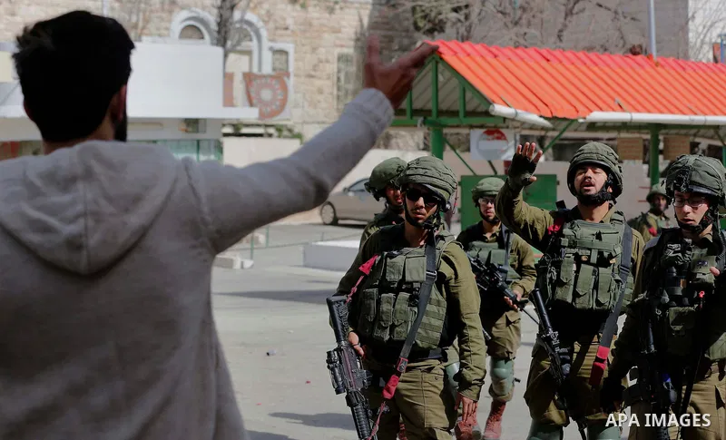 A Palestinian protester argues with Israeli soldiers during clashes following a demonstration demanding to dismantle the Ghetto, to mark the 24th anniversary of Ibrahimi mosque massacre when Baruch Goldstein an Israeli s...