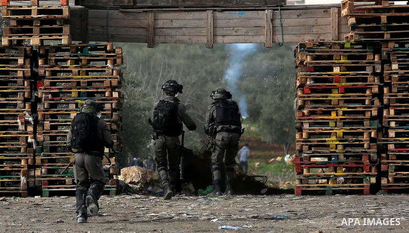 Israeli security forces take position during clashes with Palestinian protesters in the occupied West Bank village of Baita, just outside of Nablus, on February 16, 2018. Photo by Shadi Jarar'ah