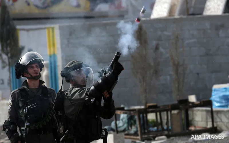 A member of Israeli security forces fires a tear gas canister towards Palestinian protesters during clashes in the occupied West Bank village of Baita, outside of Nablus, on February 16, 2018. Photo by Shadi Jarar'ah