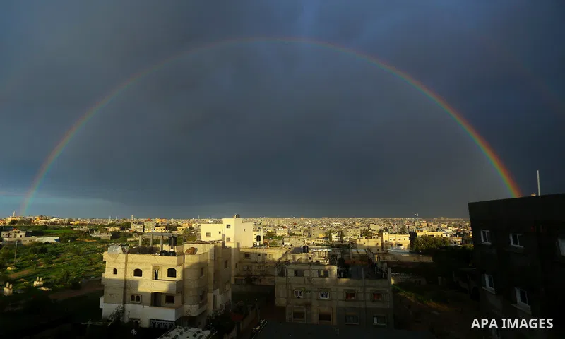 A picture taken on February 17, 2018 shows a rainbow appearing over the Khan Younis city in the southern Gaza Strip. Photo by Yasser Qudih