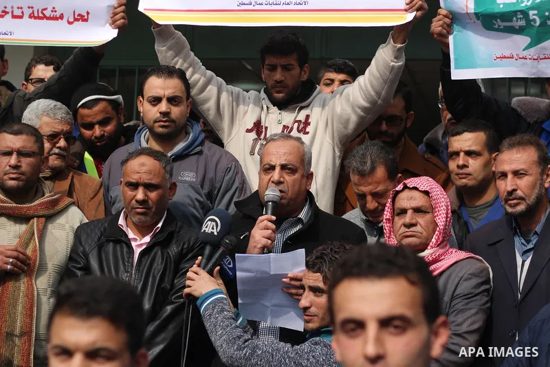 Palestinian cleaners hold banners during a protest to demand their salaries, in Gaza City on February 18, 2018. Photo by Mahmoud Ajour