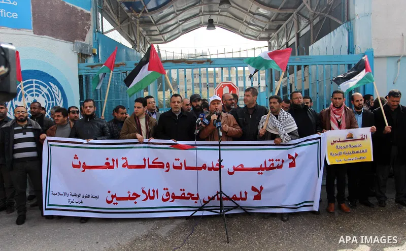 Palestinians hold placards during a protest against the US move to freeze funding for the UN agency for Palestinian refugees, in front of the headquarters United Nations Relief and Works Agency (UNRWA), in Gaza City on F...