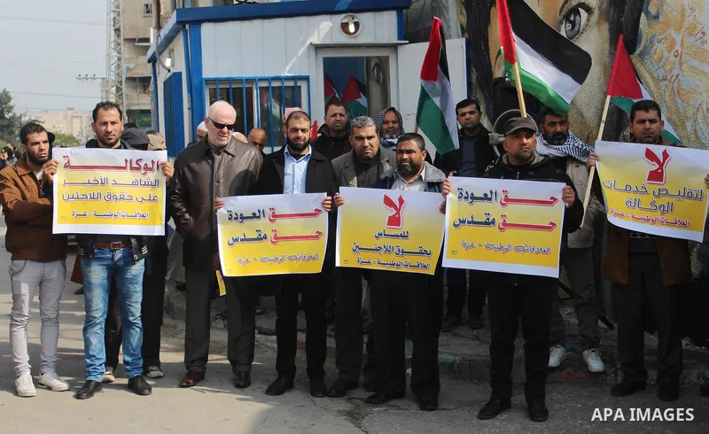 Palestinians hold placards during a protest against the US move to freeze funding for the UN agency for Palestinian refugees, in front of the headquarters United Nations Relief and Works Agency (UNRWA), in Gaza City on F...