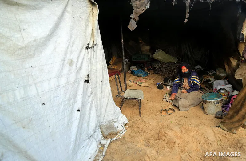 A Palestinian woman sits at her house in an impoverished area in Gaza City on February 18, 2018. Photo by Dawoud Abo Alkas