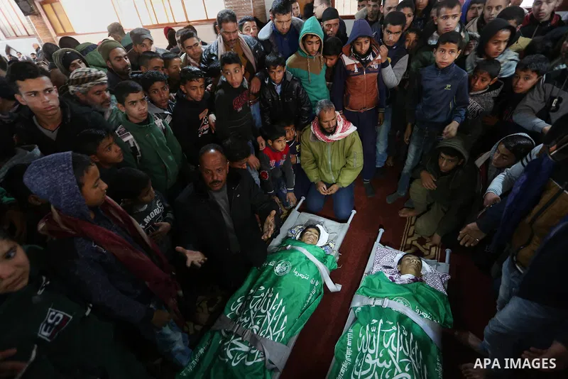 Relatives mourn over the bodies of two Palestinian teenagers, who were killed following Israeli air strikes, during their funeral, in Rafah in the southern Gaza Strip on February 18, 2018. Two Palestinians were killed by...