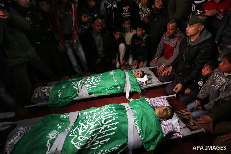 Relatives mourn over the bodies of two Palestinian teenagers, who were killed following Israeli air strikes, during their funeral, in Rafah in the southern Gaza Strip on February 18, 2018. Two Palestinians were killed by...