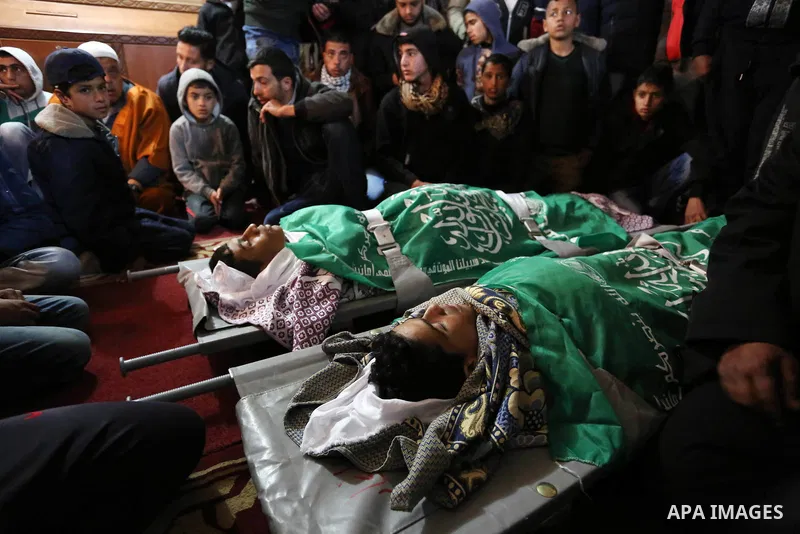 Relatives mourn over the bodies of two Palestinian teenagers, who were killed following Israeli air strikes, during their funeral, in Rafah in the southern Gaza Strip on February 18, 2018. Two Palestinians were killed by...