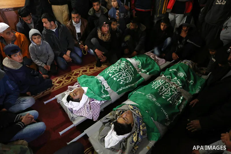 Relatives mourn over the bodies of two Palestinian teenagers, who were killed following Israeli air strikes, during their funeral, in Rafah in the southern Gaza Strip on February 18, 2018. Two Palestinians were killed by...