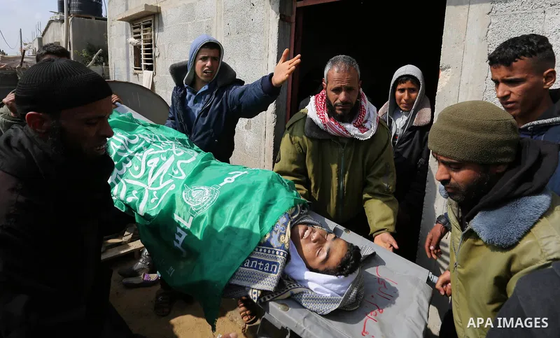Mourners carry the body of one of two Palestinian teenagers, who were killed following Israeli air strikes, during their funeral, in Rafah in the southern Gaza Strip on February 18, 2018. Two Palestinians were killed by...