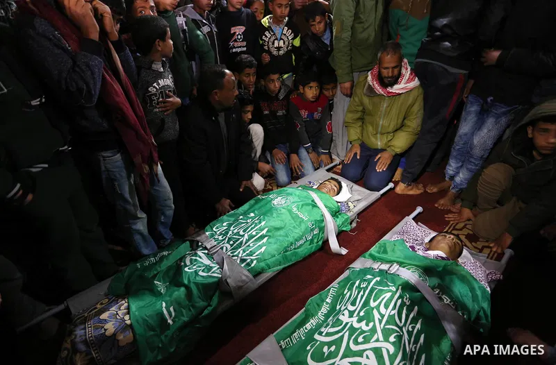 Relatives mourn over the bodies of two Palestinian teenagers, who were killed following Israeli air strikes, during their funeral, in Rafah in the southern Gaza Strip on February 18, 2018. Two Palestinians were killed by...