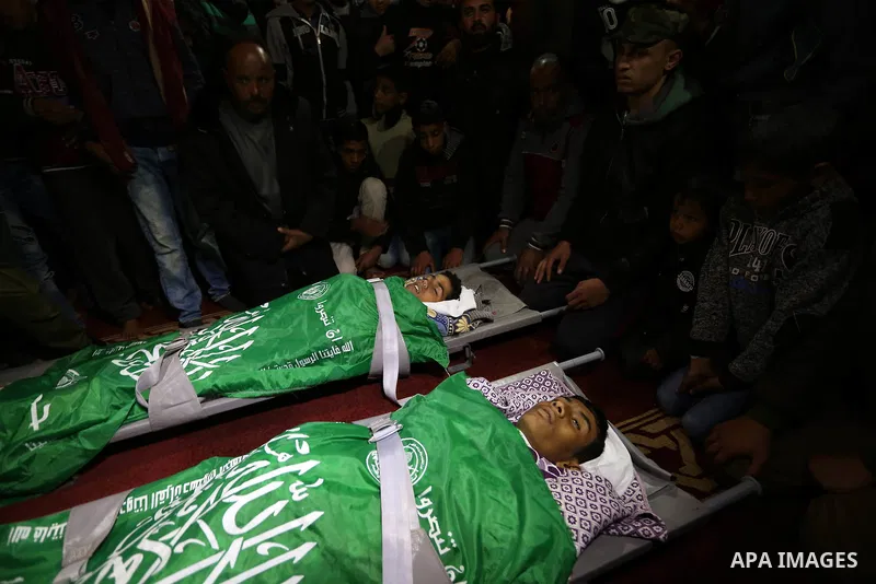 Relatives mourn over the bodies of two Palestinian teenagers, who were killed following Israeli air strikes, during their funeral, in Rafah in the southern Gaza Strip on February 18, 2018. Two Palestinians were killed by...