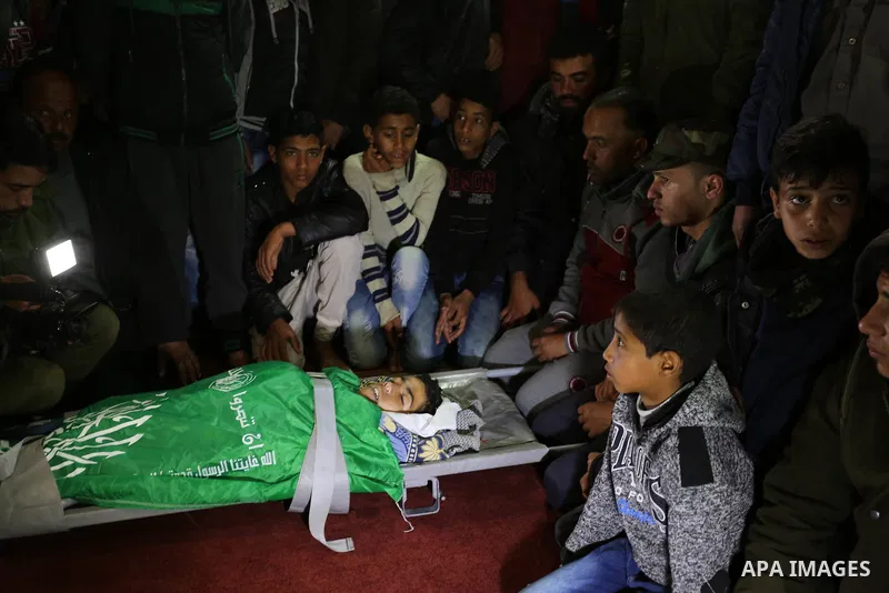 Relatives mourn over the bodies of two Palestinian teenagers, who were killed following Israeli air strikes, during their funeral, in Rafah in the southern Gaza Strip on February 18, 2018. Two Palestinians were killed by...