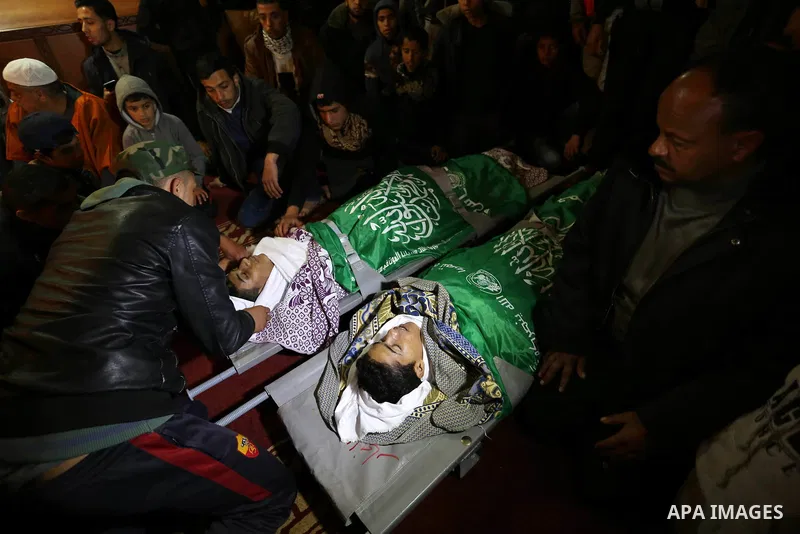 Relatives mourn over the bodies of two Palestinian teenagers, who were killed following Israeli air strikes, during their funeral, in Rafah in the southern Gaza Strip on February 18, 2018. Two Palestinians were killed by...