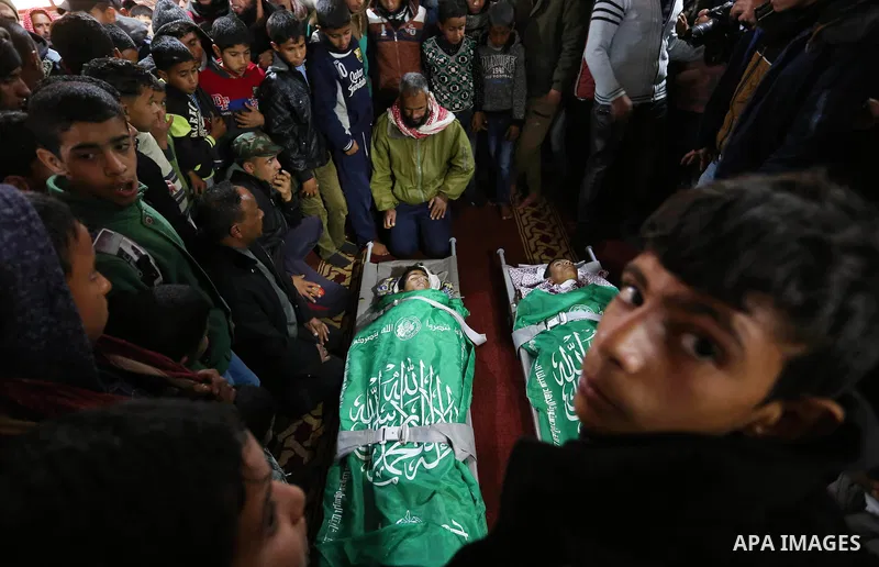 Relatives mourn over the bodies of two Palestinian teenagers, who were killed following Israeli air strikes, during their funeral, in Rafah in the southern Gaza Strip on February 18, 2018. Two Palestinians were killed by...