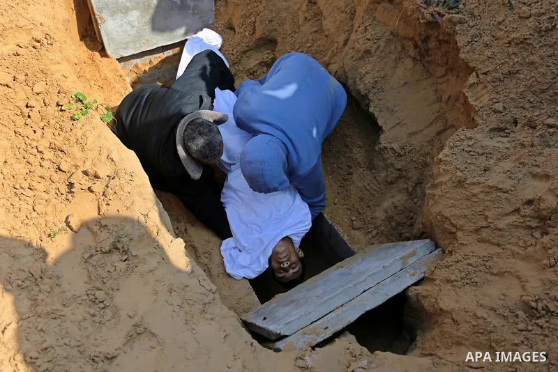 Mourners bury the body of one of two Palestinian teenagers who were killed following Israeli air strikes, during their funeral, in Rafah in the southern Gaza Strip on February 18, 2018. Two Palestinians were killed by Is...