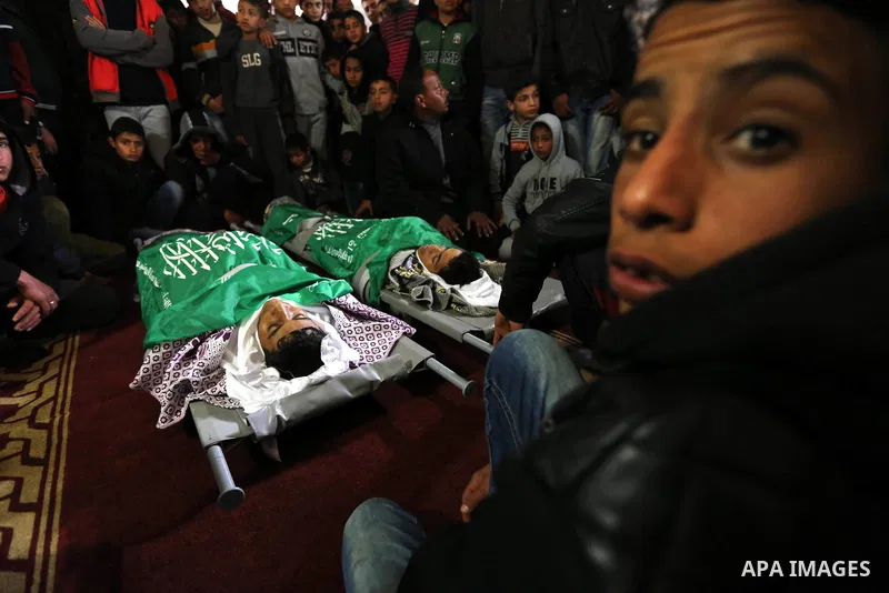 Relatives mourn over the bodies of two Palestinian teenagers, who were killed following Israeli air strikes, during their funeral, in Rafah in the southern Gaza Strip on February 18, 2018. Two Palestinians were killed by...