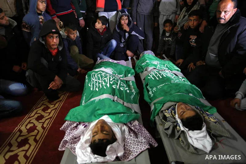 Relatives mourn over the bodies of two Palestinian teenagers, who were killed following Israeli air strikes, during their funeral, in Rafah in the southern Gaza Strip on February 18, 2018. Two Palestinians were killed by...