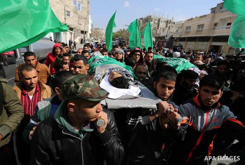 Mourners carry the bodies of two Palestinian teenagers, who were killed following Israeli air strikes, during their funeral, in Rafah in the southern Gaza Strip on February 18, 2018. Two Palestinians were killed by Israe...