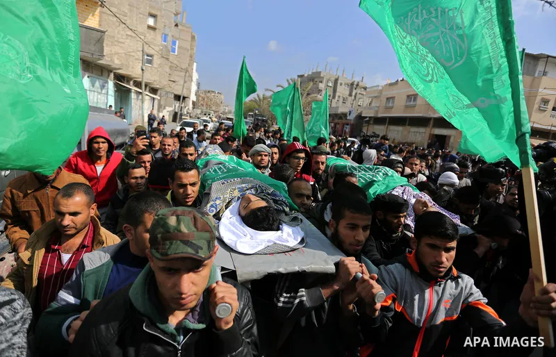 Mourners carry the bodies of two Palestinian teenagers, who were killed following Israeli air strikes, during their funeral, in Rafah in the southern Gaza Strip on February 18, 2018. Two Palestinians were killed by Israe...