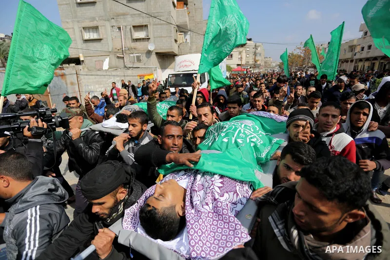 Mourners carry the bodies of two Palestinian teenagers, who were killed following Israeli air strikes, during their funeral, in Rafah in the southern Gaza Strip on February 18, 2018. Two Palestinians were killed by Israe...