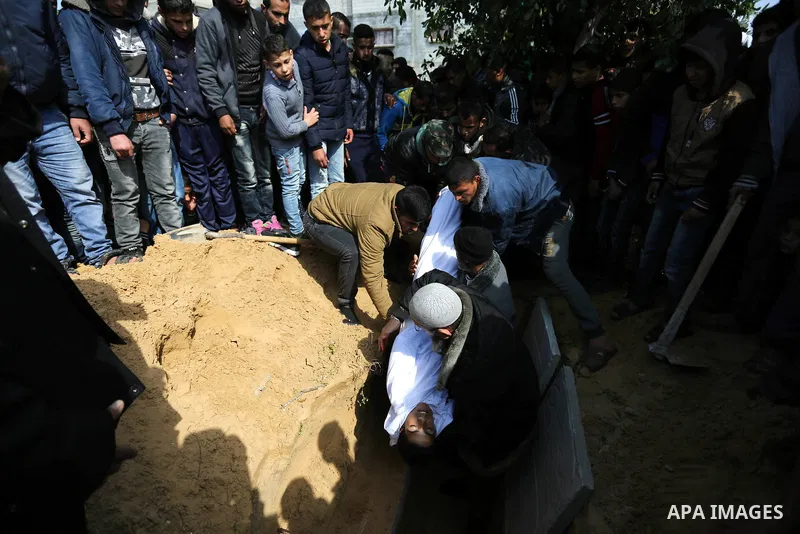 Mourners bury the body of one of two Palestinian teenagers who were killed following Israeli air strikes, during their funeral, in Rafah in the southern Gaza Strip on February 18, 2018. Two Palestinians were killed by Is...