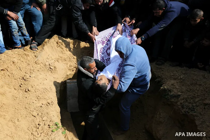 Mourners bury the body of one of two Palestinian teenagers who were killed following Israeli air strikes, during their funeral, in Rafah in the southern Gaza Strip on February 18, 2018. Two Palestinians were killed by Is...