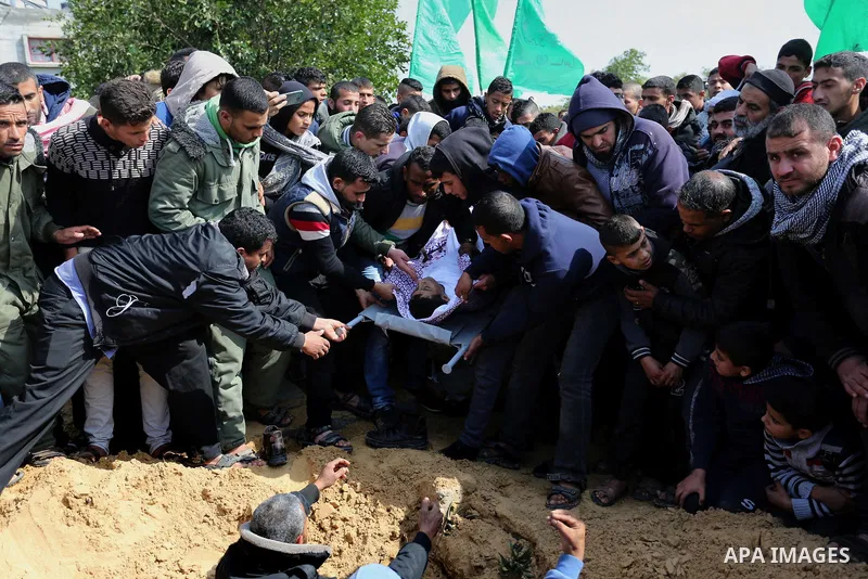 Mourners bury the body of one of two Palestinian teenagers who were killed following Israeli air strikes, during their funeral, in Rafah in the southern Gaza Strip on February 18, 2018. Two Palestinians were killed by Is...
