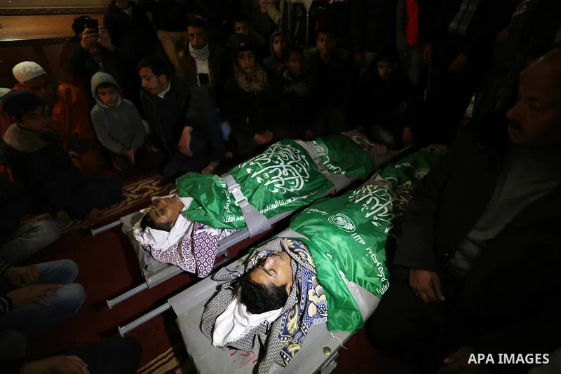 Relatives mourn over the bodies of two Palestinian teenagers, who were killed following Israeli air strikes, during their funeral, in Rafah in the southern Gaza Strip on February 18, 2018. Two Palestinians were killed by...