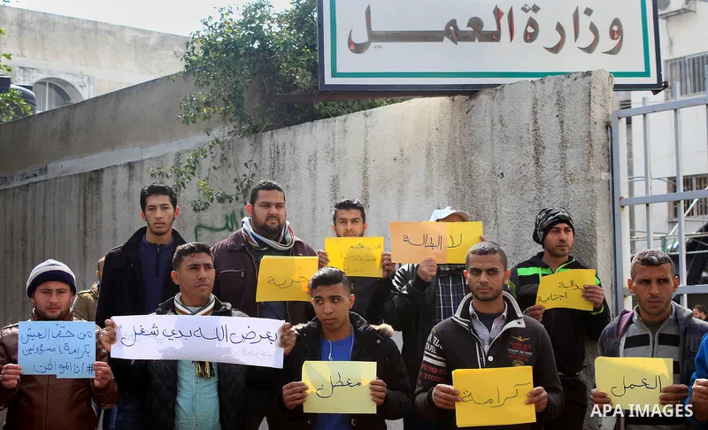 Palestinian graduates hold placards during a protest to demand their rights, outside the Ministry of Labor headquarters in Gaza city on February 18, 2018. Photo by Amjad Hassan