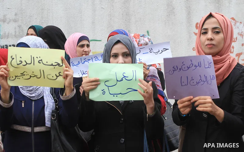 Palestinian graduates hold placards during a protest to demand their rights, outside the Ministry of Labor headquarters in Gaza city on February 18, 2018. Photo by Amjad Hassan