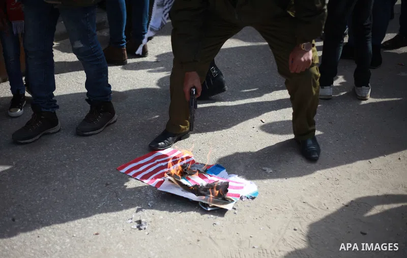 A Palestinian demonstrator burns an Israeli, British and U.S. flags during a protest to show solidarity with Palestinian prisoners held in Israeli jails, in front of Red cross office in Gaza city on February 19, 2018. Ph...