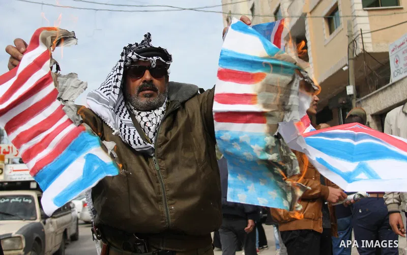 A Palestinian demonstrator burns an Israeli, British and U.S. flags during a protest to show solidarity with Palestinian prisoners held in Israeli jails, in front of Red cross office in Gaza city on February 19, 2018. Ph...