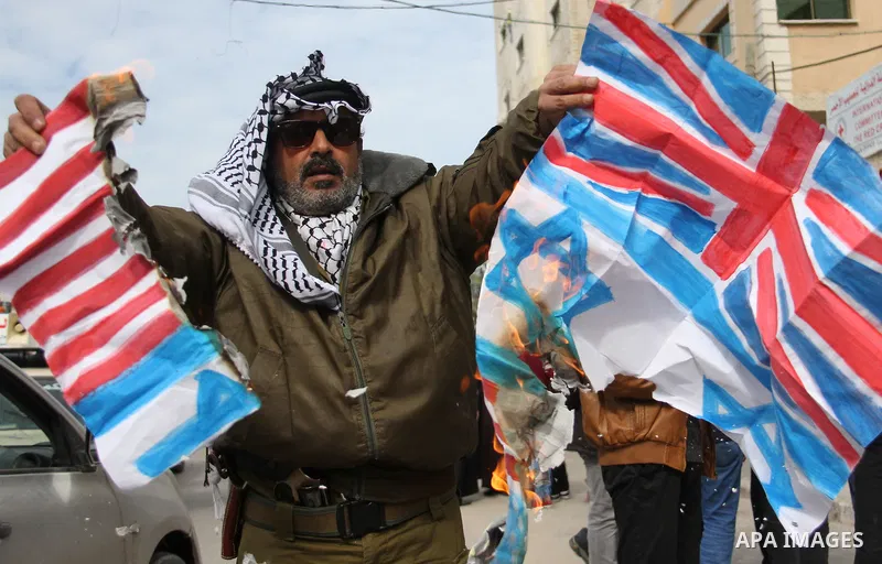 A Palestinian demonstrator burns an Israeli, British and U.S. flags during a protest to show solidarity with Palestinian prisoners held in Israeli jails, in front of Red cross office in Gaza city on February 19, 2018. Ph...