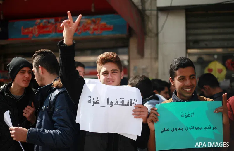 Palestinian employees of Gaza strip hold banners during a demonstration demanding their salaries in Gaza city on February 19, 2018. Photo by Mahmoud Ajour
