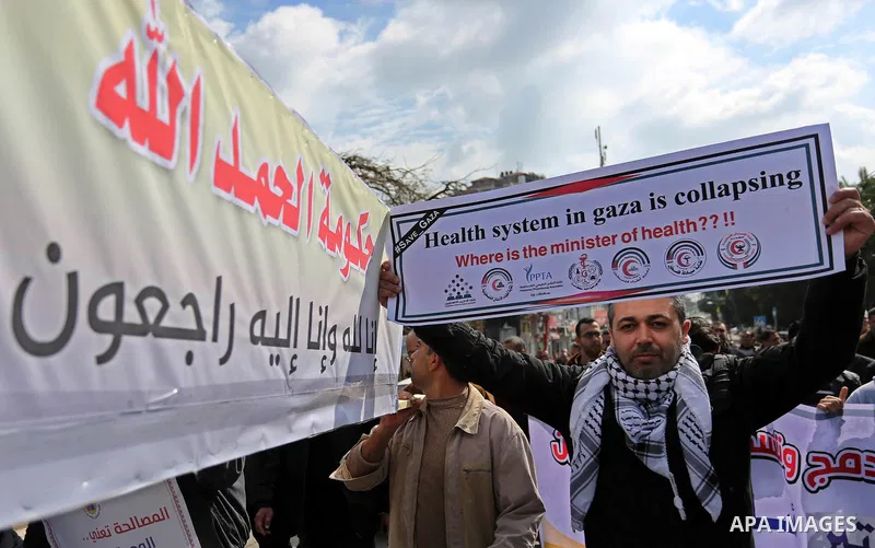Palestinian employees of Gaza strip hold banners during a demonstration demanding their salaries in Gaza city on February 19, 2018. Photo by Ashraf Amra