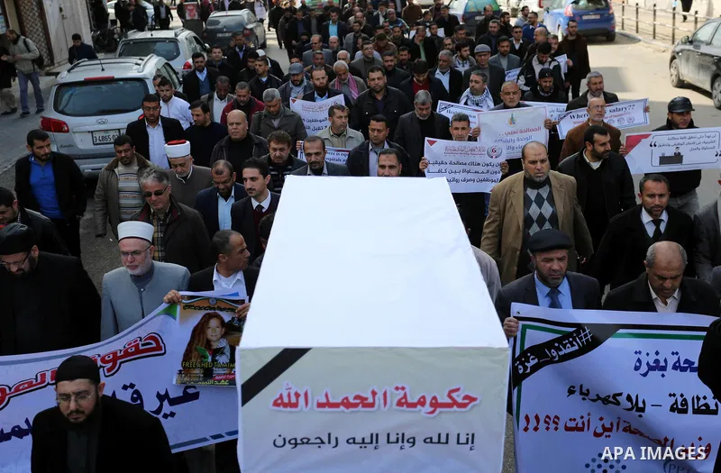 Palestinian employees of Gaza strip hold banners during a demonstration demanding their salaries in Gaza city on February 19, 2018. Photo by Ashraf Amra